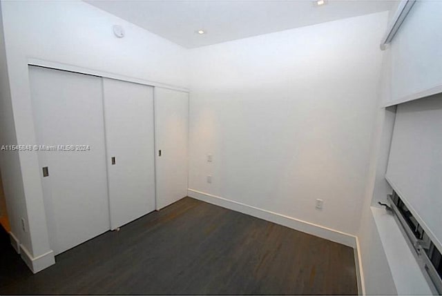 unfurnished bedroom featuring a closet and dark hardwood / wood-style floors