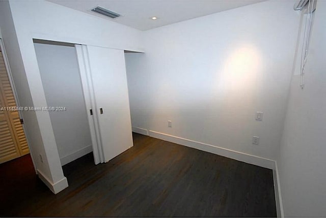 unfurnished bedroom with dark wood-type flooring