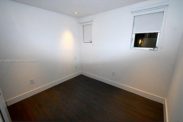 empty room with dark hardwood / wood-style flooring