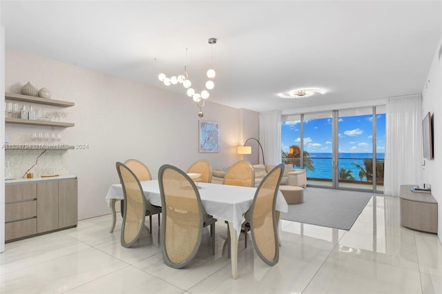 tiled dining room with a chandelier and a wall of windows