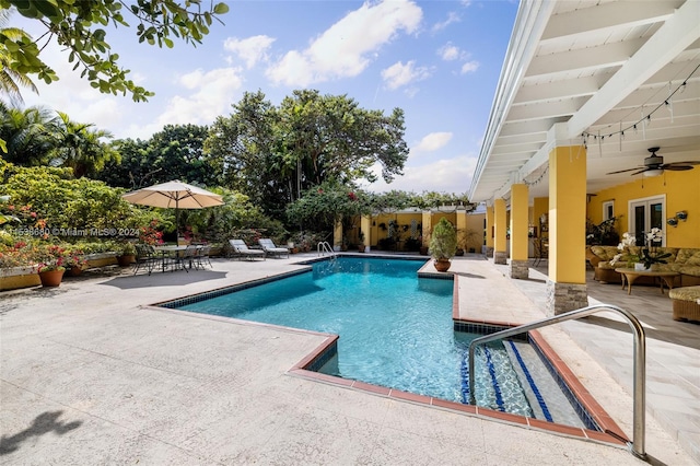 view of swimming pool with ceiling fan and a patio