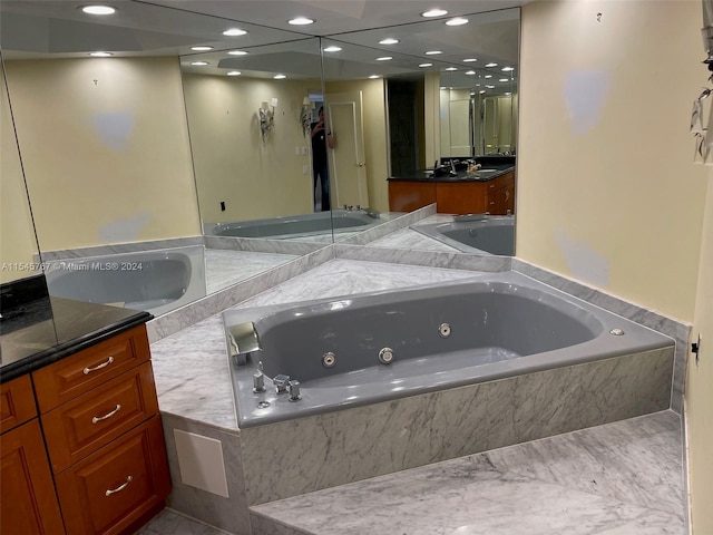 bathroom featuring vanity and tiled bath