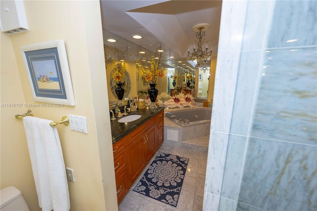 bathroom featuring tile patterned floors, toilet, a relaxing tiled tub, an inviting chandelier, and vanity