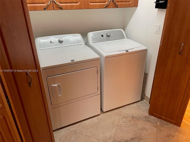 laundry room with independent washer and dryer and cabinets