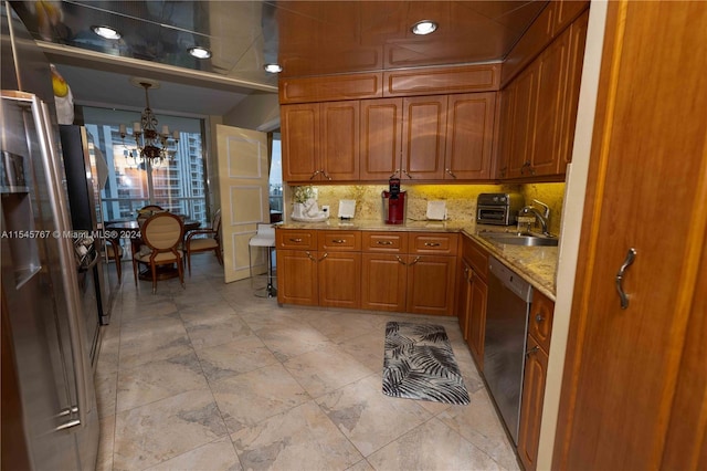 kitchen with decorative backsplash, light stone counters, stainless steel dishwasher, a notable chandelier, and decorative light fixtures