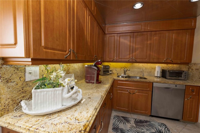 kitchen with backsplash, light stone countertops, dishwasher, light tile patterned flooring, and sink