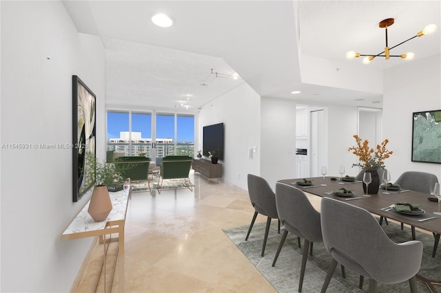 dining room with an inviting chandelier and a wall of windows