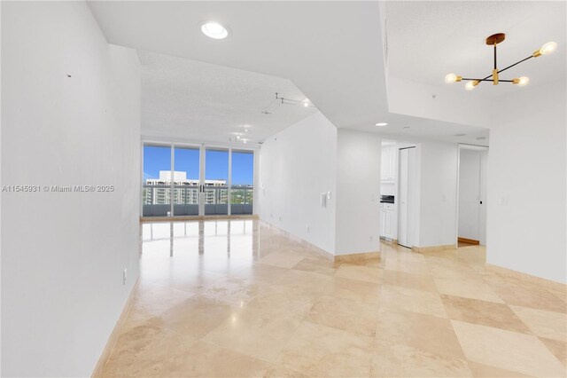 unfurnished room featuring expansive windows and track lighting