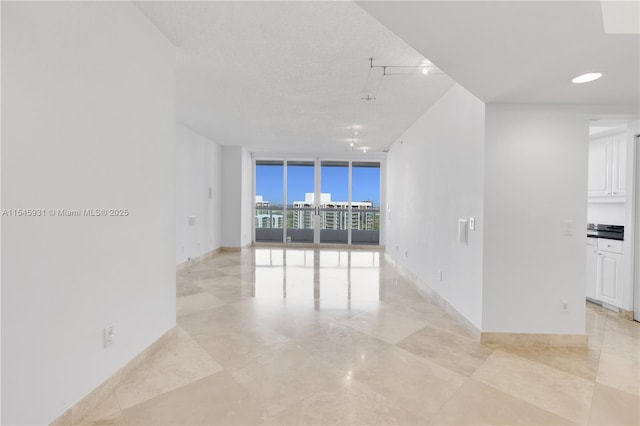 empty room featuring floor to ceiling windows and a textured ceiling