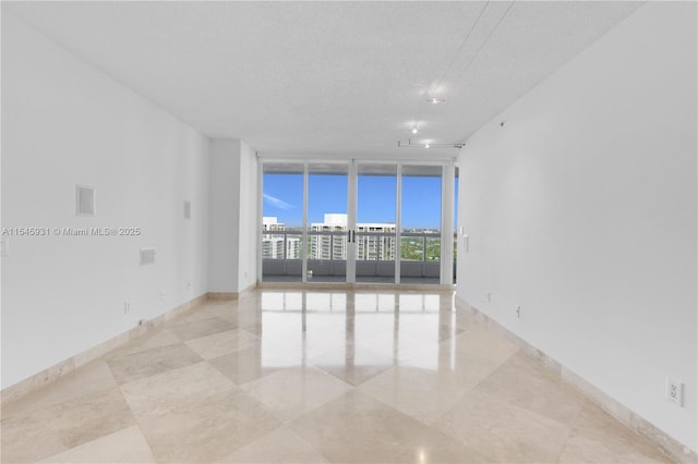 empty room featuring expansive windows and a textured ceiling