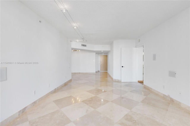 unfurnished room with a textured ceiling