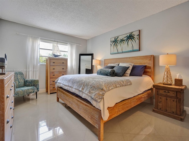 bedroom featuring a textured ceiling and light tile patterned floors