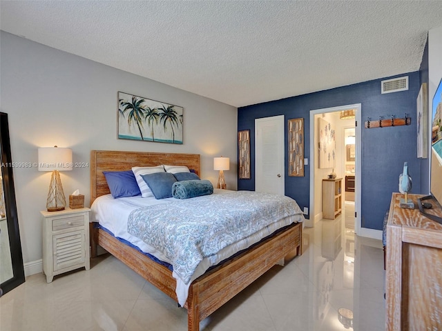 bedroom with connected bathroom and a textured ceiling