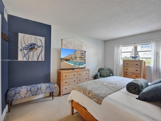 bedroom with a textured ceiling and light tile patterned floors