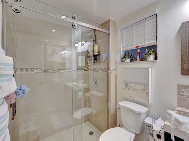 bathroom with a shower with door and toilet