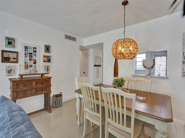 tiled dining space with a textured ceiling