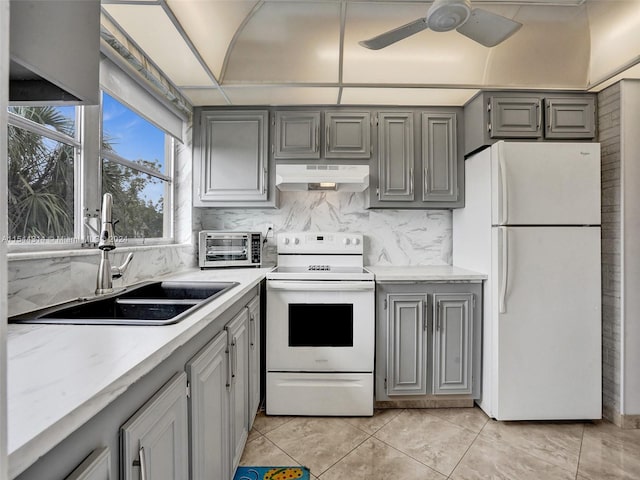 kitchen with white appliances, ceiling fan, light tile floors, gray cabinetry, and wall chimney exhaust hood