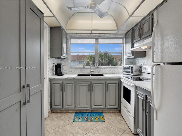 kitchen with ceiling fan, light tile flooring, white appliances, sink, and tasteful backsplash