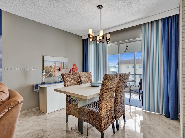 dining area featuring a chandelier, light tile floors, and a textured ceiling