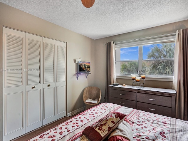 bedroom featuring a closet, dark wood-type flooring, and a textured ceiling