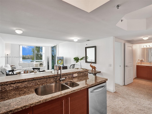 kitchen featuring light colored carpet, sink, dishwasher, and dark stone counters