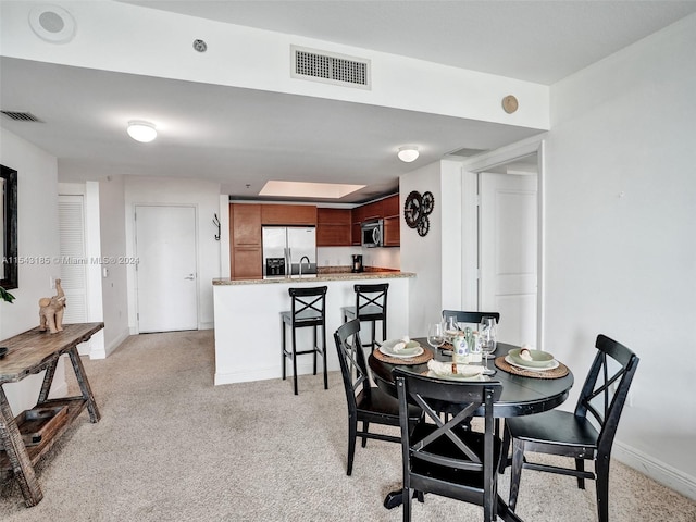 dining room featuring light carpet and sink