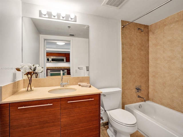 full bathroom with vanity, tile floors, toilet, and tiled shower / bath