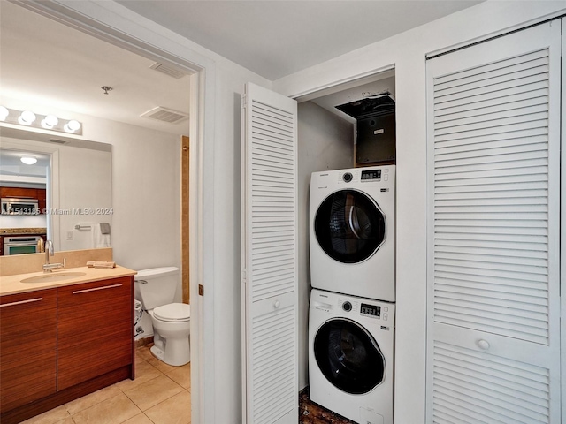 washroom with stacked washing maching and dryer, sink, and light tile floors