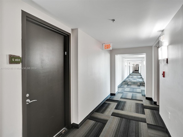 hall featuring dark colored carpet