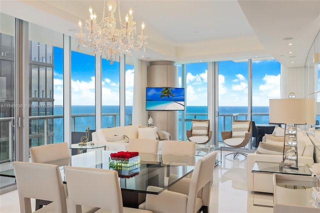 tiled dining space featuring a wealth of natural light, a water view, expansive windows, and a notable chandelier