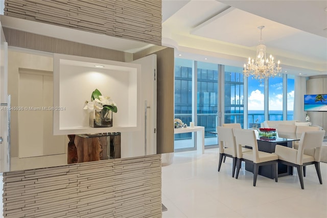 dining space featuring an inviting chandelier, a water view, and tile patterned flooring