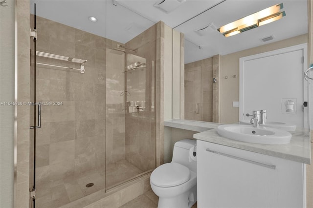 bathroom with a shower with shower door, vanity, and toilet