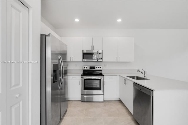 kitchen featuring white cabinets, appliances with stainless steel finishes, light tile patterned flooring, and sink