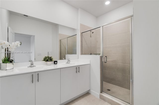 bathroom with tile patterned flooring, vanity, and a shower with shower door