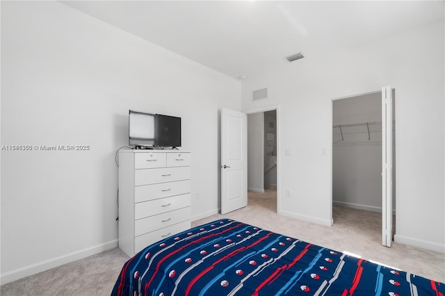 bedroom with light colored carpet, a spacious closet, and a closet