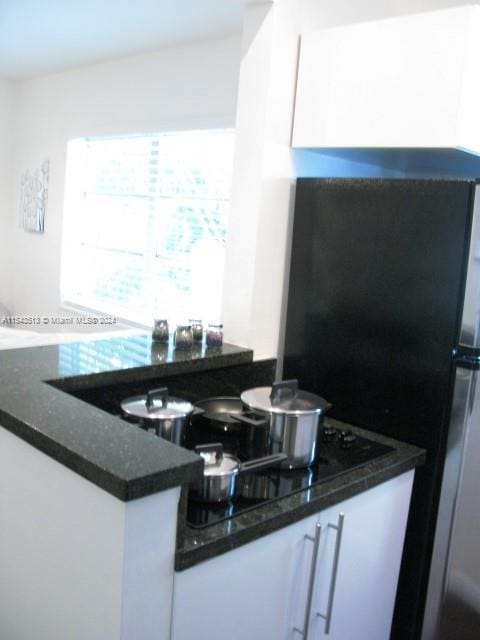 kitchen with white cabinets and dark stone countertops