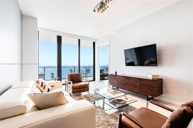 living room with floor to ceiling windows, a water view, and a chandelier