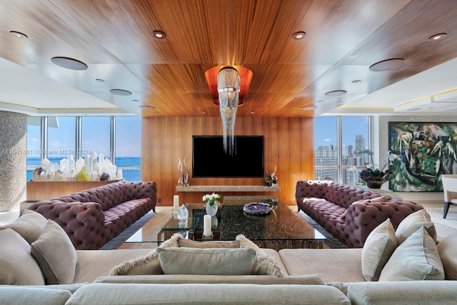 living room featuring wooden ceiling, wood walls, a wall of windows, and a water view