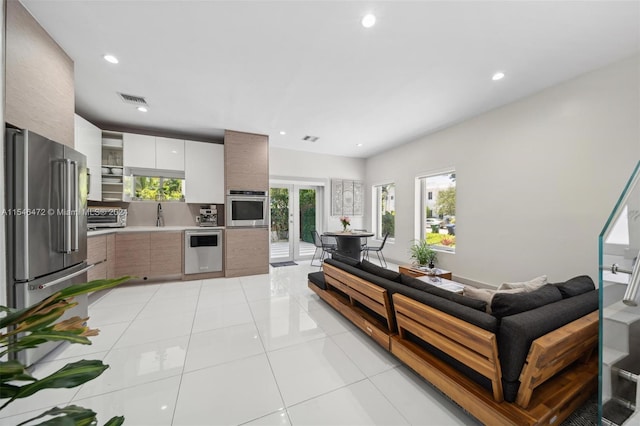 living room with light tile patterned floors, french doors, and a healthy amount of sunlight