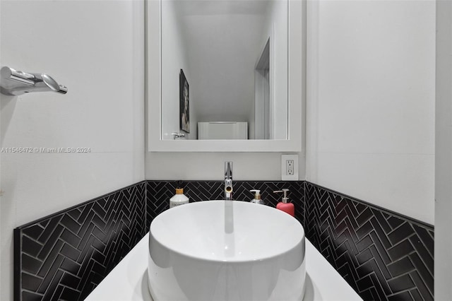 bathroom with tile walls and sink