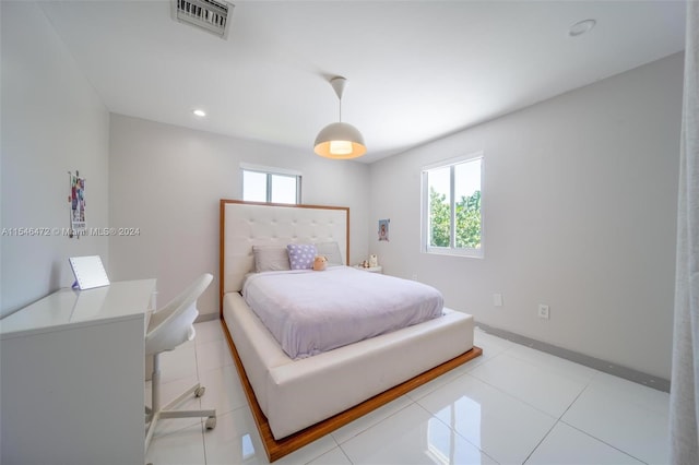 bedroom with multiple windows and light tile patterned floors