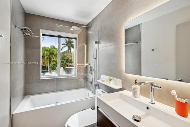 full bathroom featuring tiled shower / bath combo, vanity, and toilet