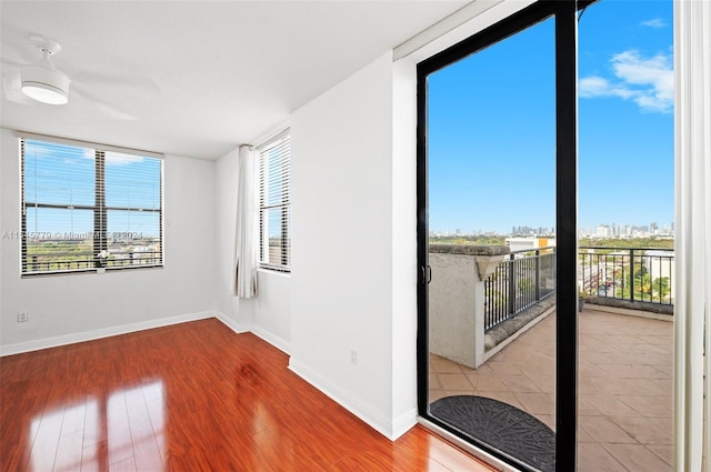 empty room with hardwood / wood-style floors and a healthy amount of sunlight