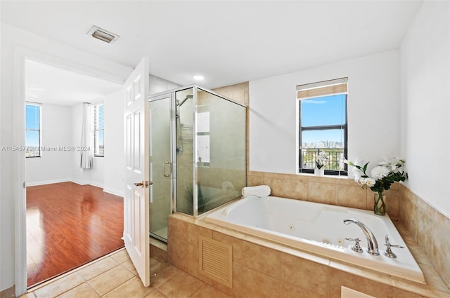 bathroom with hardwood / wood-style flooring and separate shower and tub