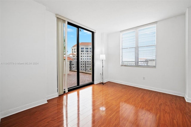 spare room featuring floor to ceiling windows and light wood-type flooring