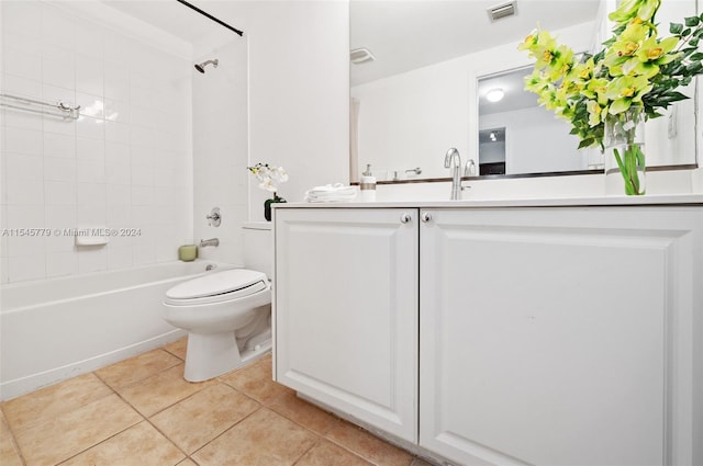 full bathroom with tiled shower / bath, toilet, tile floors, and vanity