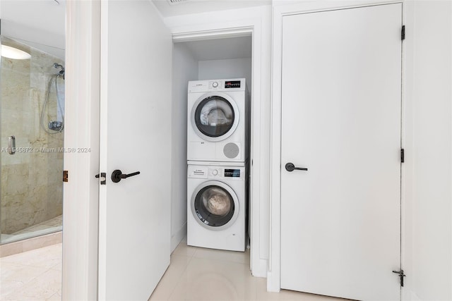 clothes washing area with stacked washer / dryer and light tile floors