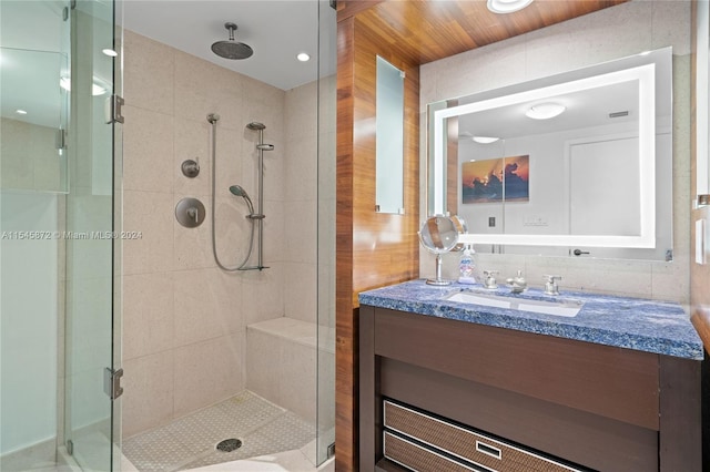 bathroom featuring vanity and a shower with shower door