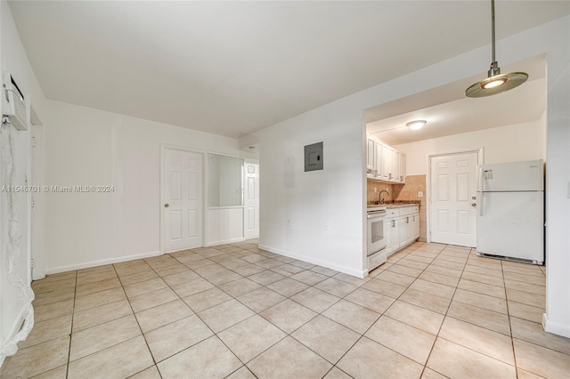 unfurnished room featuring sink and light tile floors