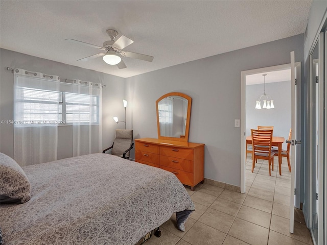 bedroom featuring a textured ceiling, ceiling fan with notable chandelier, and light tile floors